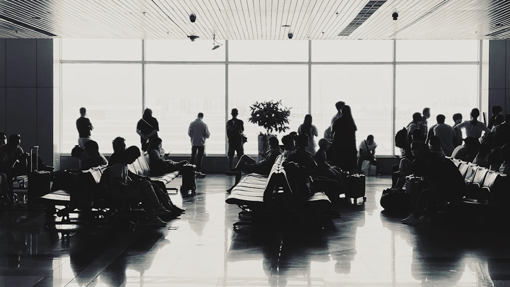 people sitting on bench in grayscale photography