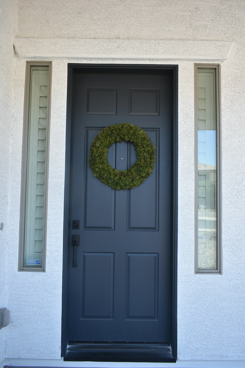 green wreath on blue wooden door