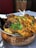 A serving of grilled, spiced chicken placed atop a bed of rice in a traditional copper bowl, garnished with fresh cilantro. The dish is likely an Indian or Middle Eastern delicacy, with vibrant colors and an appetizing presentation.