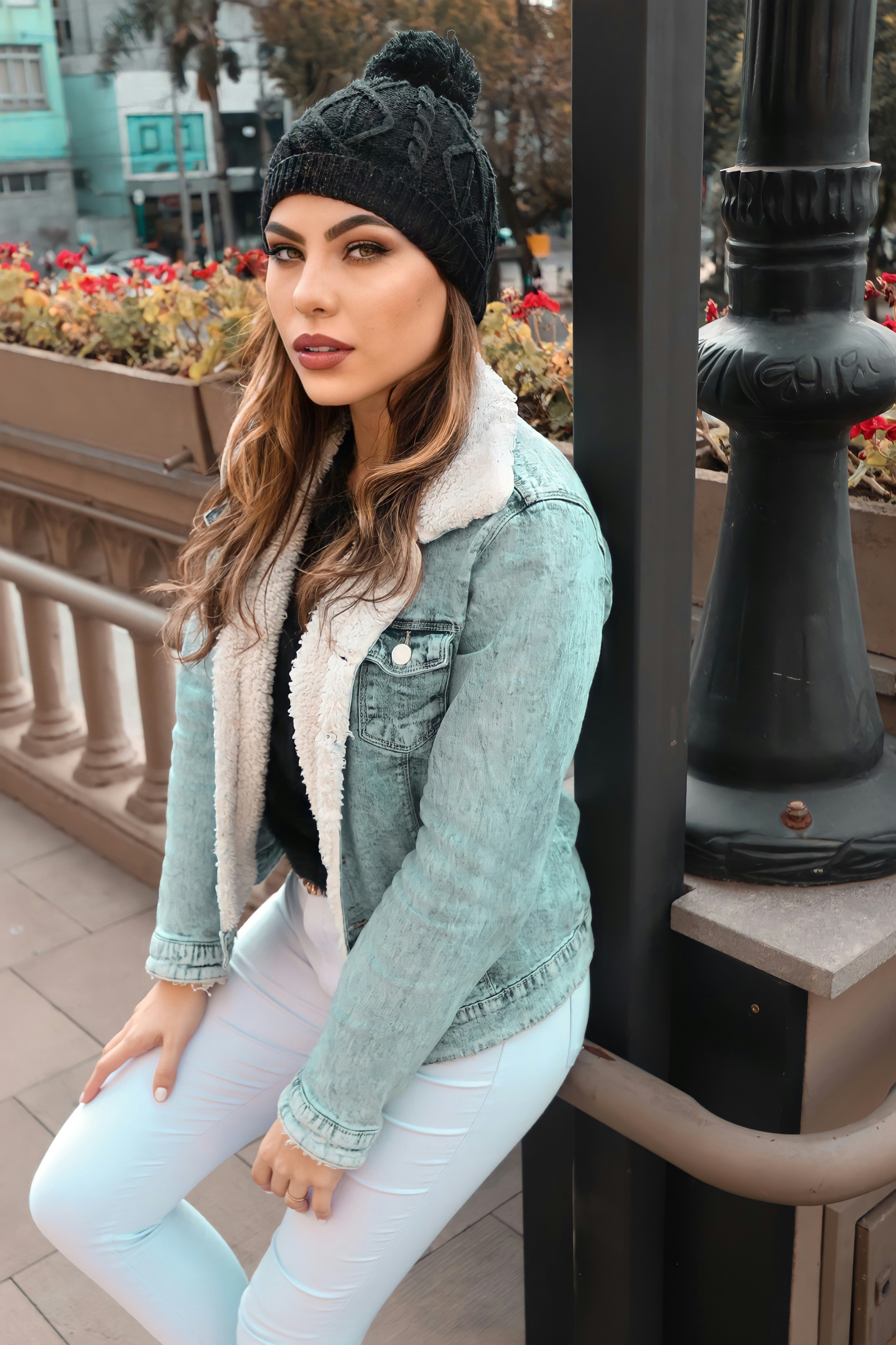 mulher na jaqueta jeans azul e shorts jeans brancos sentados no banco de madeira marrom
