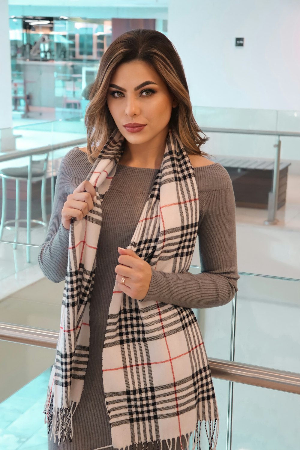 woman in brown cardigan and red white plaid dress