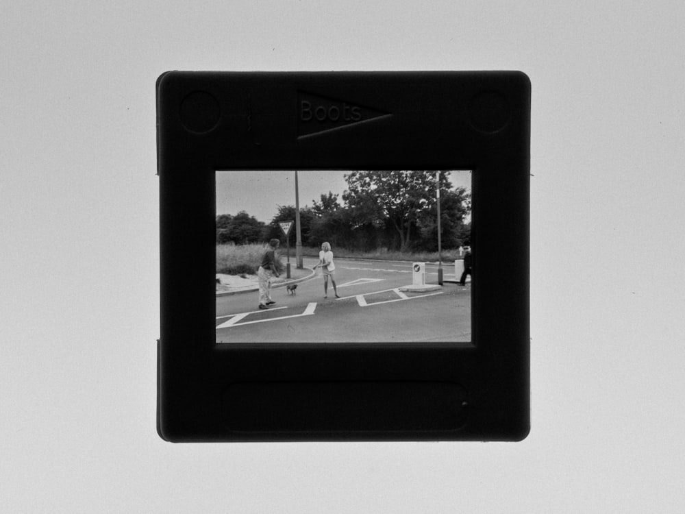 black framed photo of man and woman walking on street