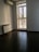 Clean, empty apartment with sunlight streaming through large windows.