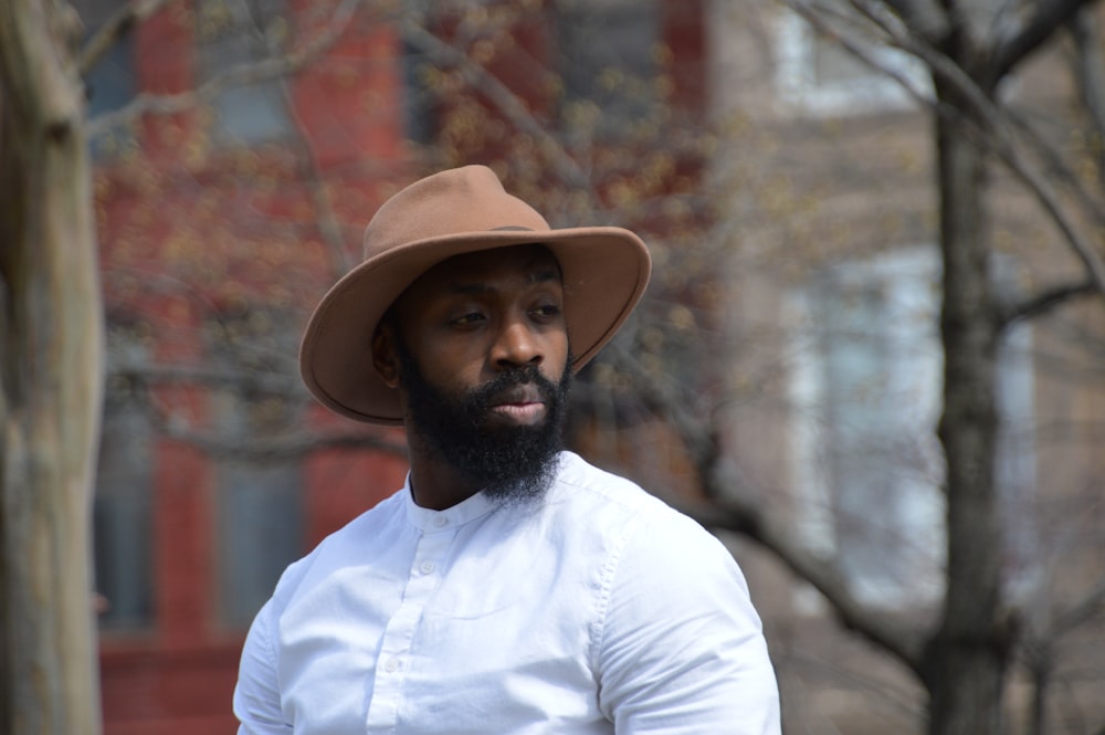 man in white dress shirt wearing brown fedora hat