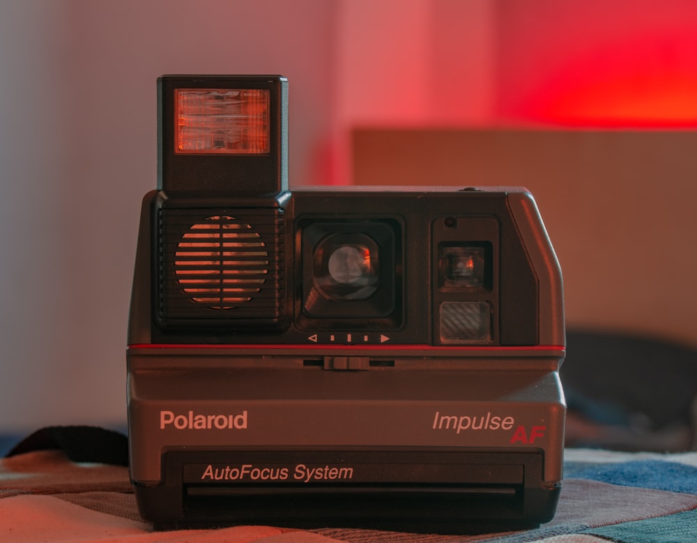 black polaroid instant camera on red surface