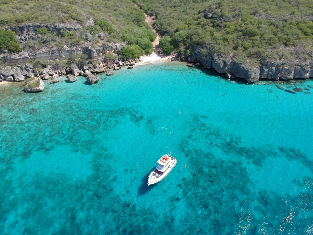 white and red boat on blue sea water during daytime