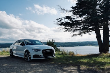 white bmw m 3 coupe parked near body of water during daytime
