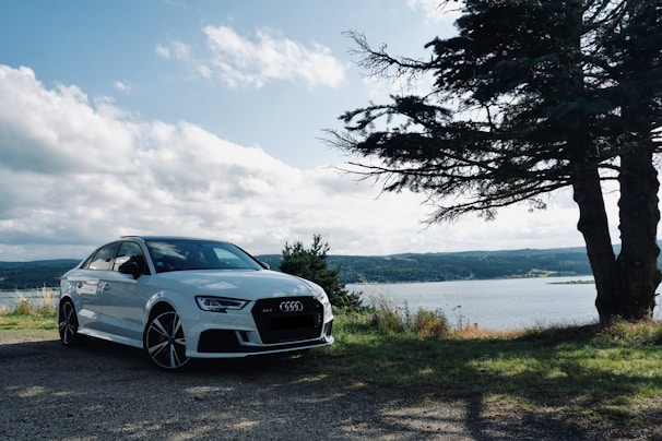 white bmw m 3 coupe parked near body of water during daytime