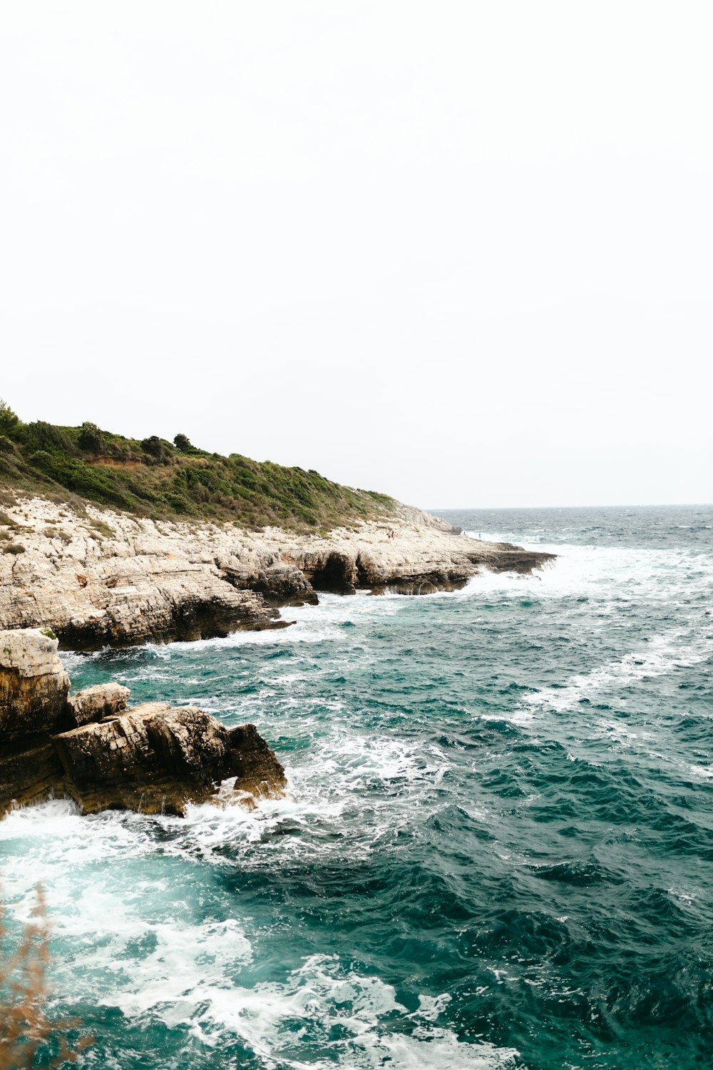 brown rock formation beside body of water during daytime