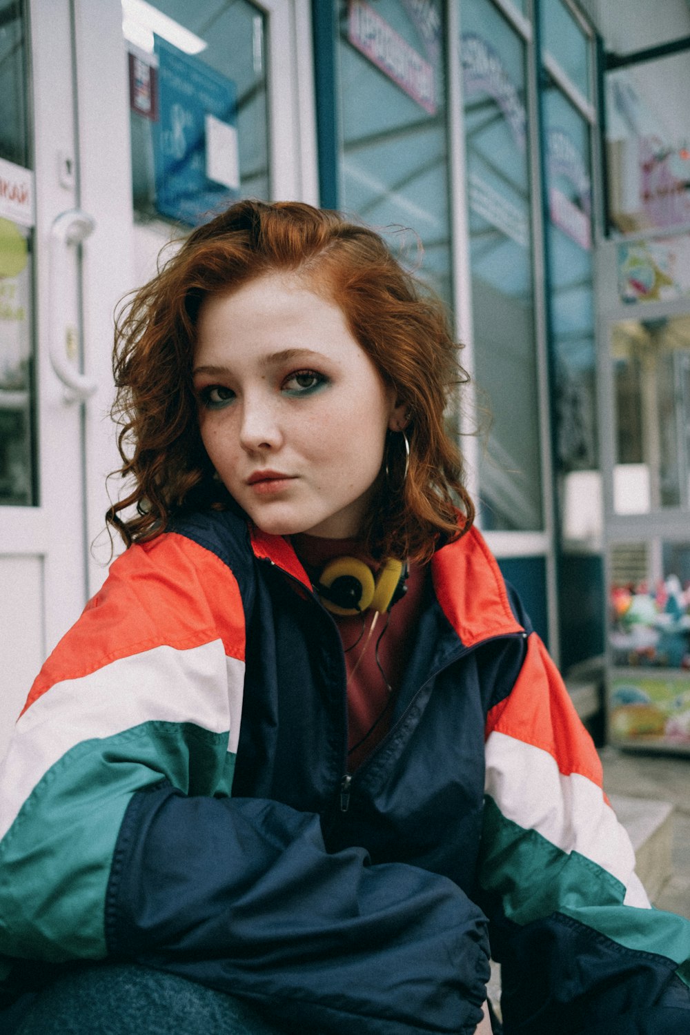 woman in blue and red jacket wearing yellow headphones