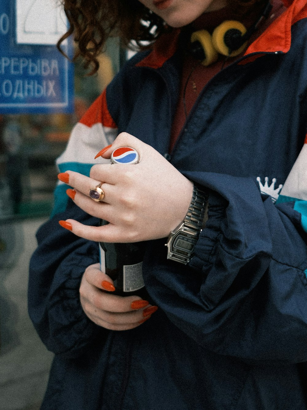 person in black jacket holding white and blue ceramic mug