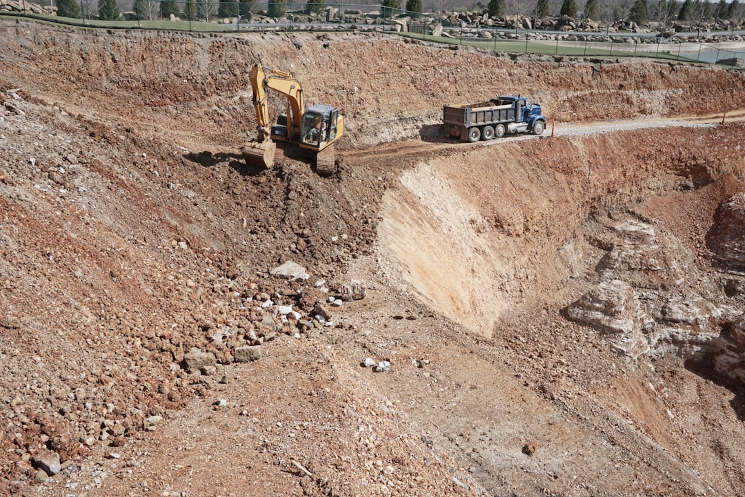 yellow and black excavator on brown dirt ground during daytime