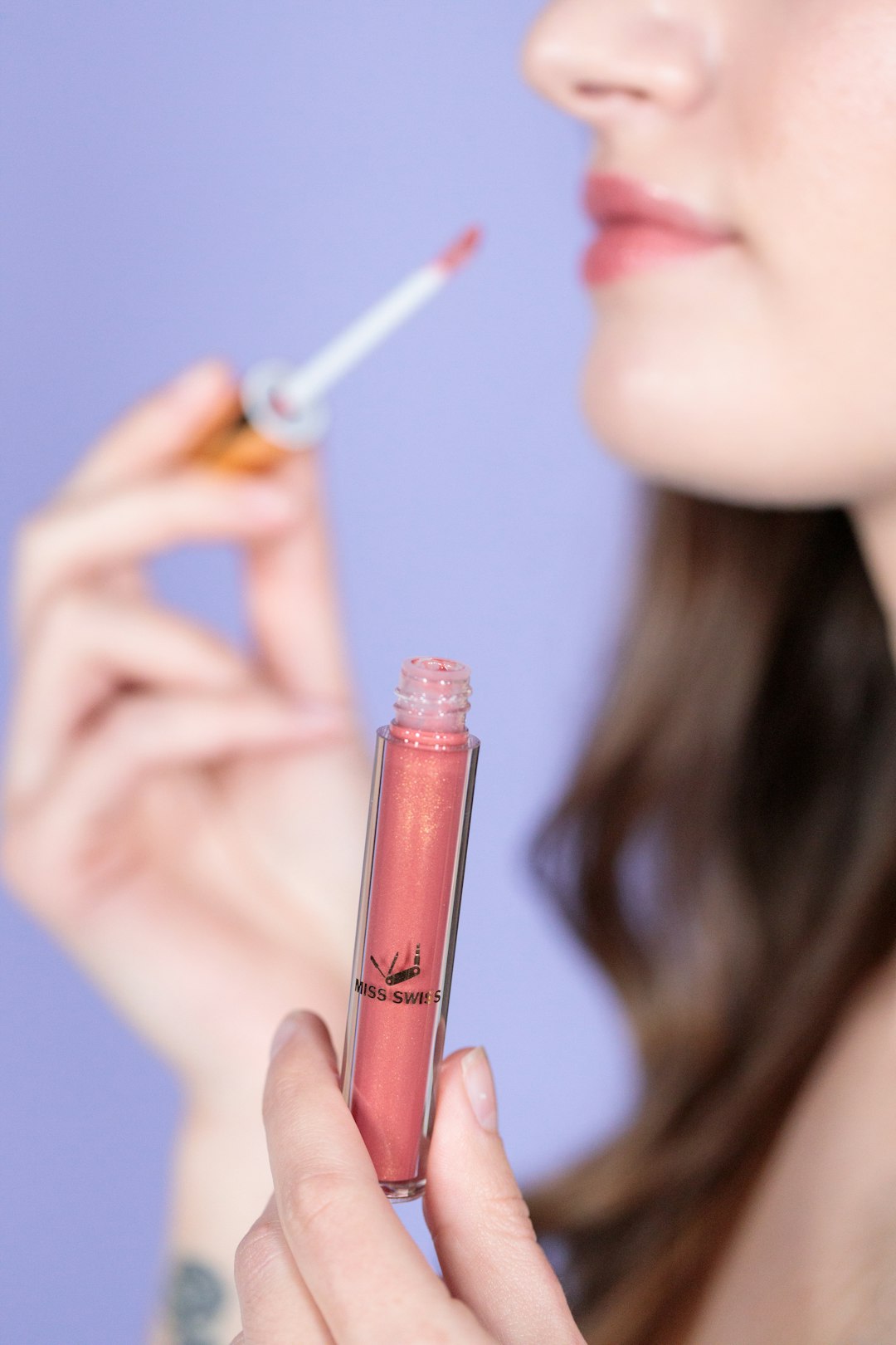 woman holding red lipstick and white cigarette stick