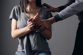 woman in gray scoop neck shirt holding her hands