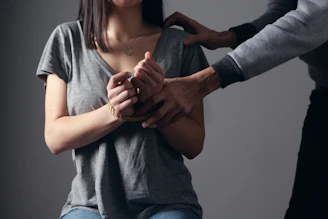 woman in gray scoop neck shirt holding her hands