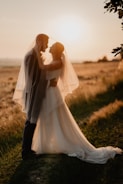A candid shot of a couple exchanging vows outdoors at sunset.