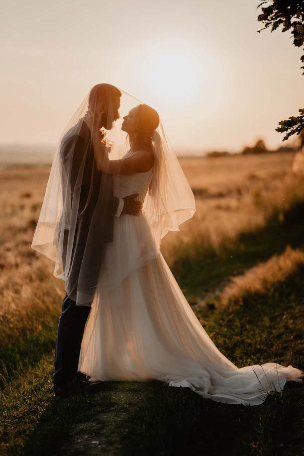 A warm, inviting scene of a couple exchanging vows outdoors with an officiant smiling nearby.
