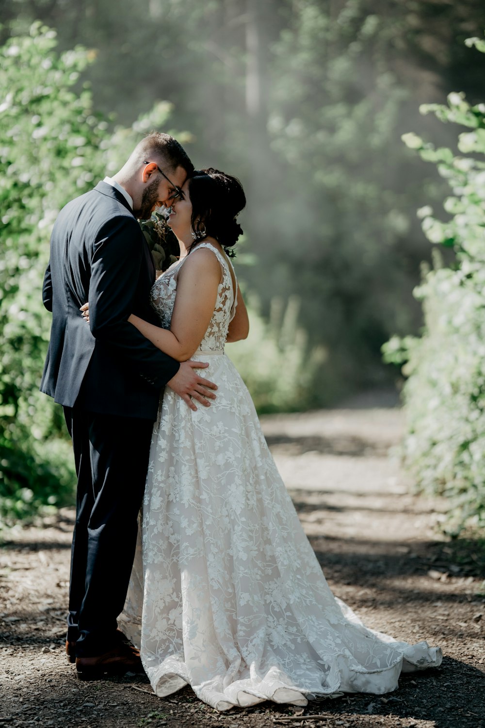 man in black suit kissing woman in white wedding dress