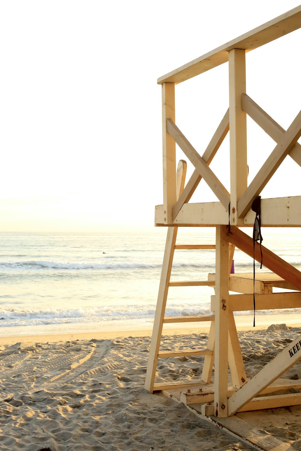 낮 동안 해변에 있는 갈색 목조 인명 구조원 타워