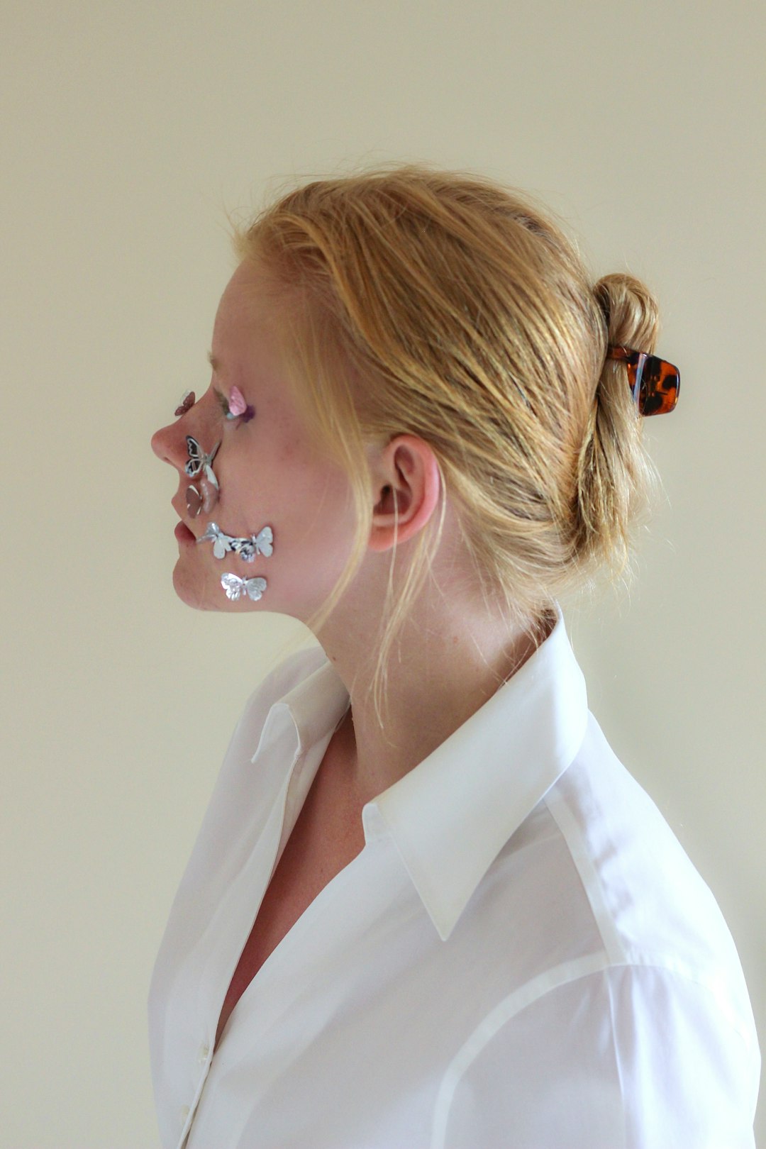 woman in white collared shirt with silver earrings