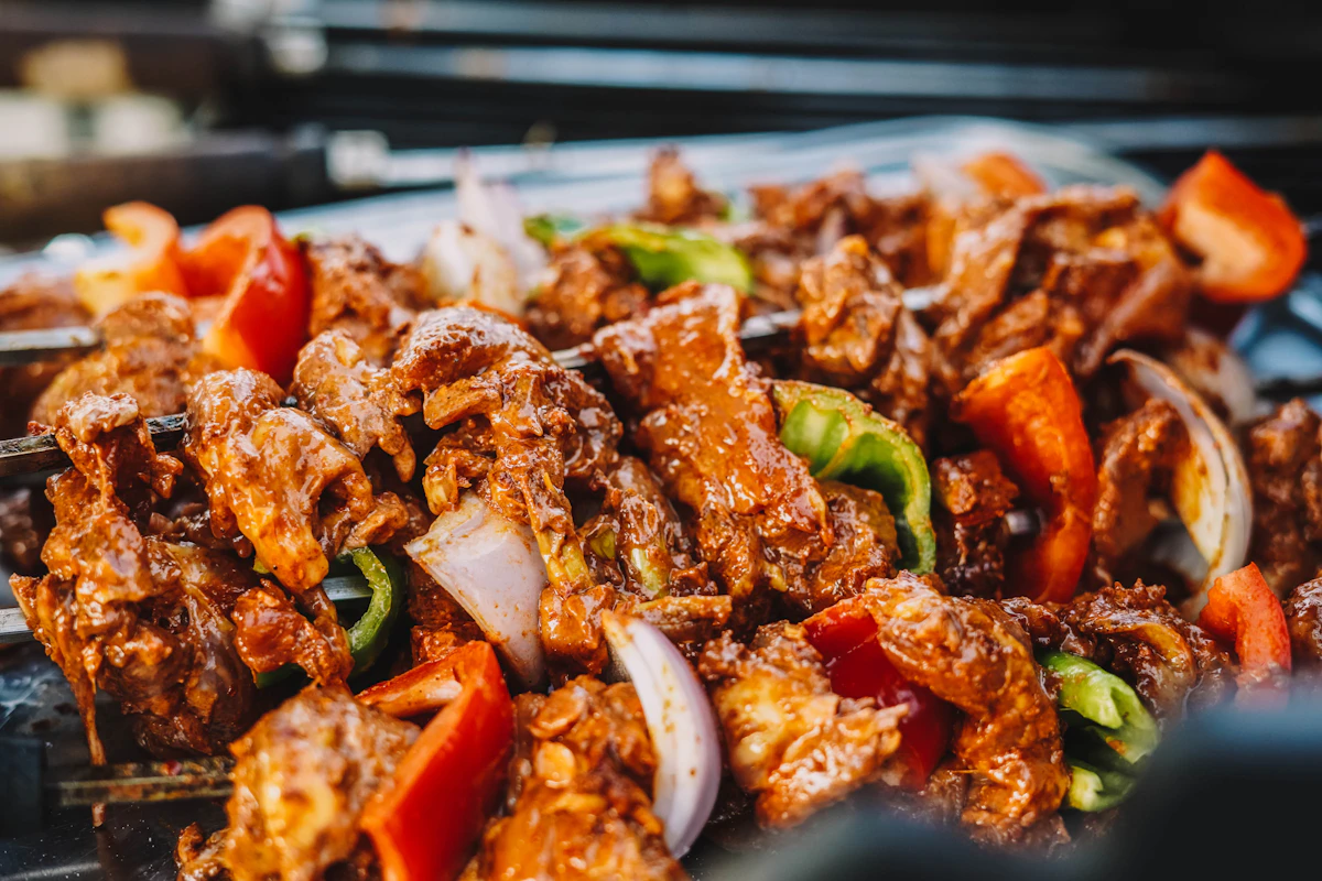 Grilled burger patties with a glossy glaze cooling on a tray