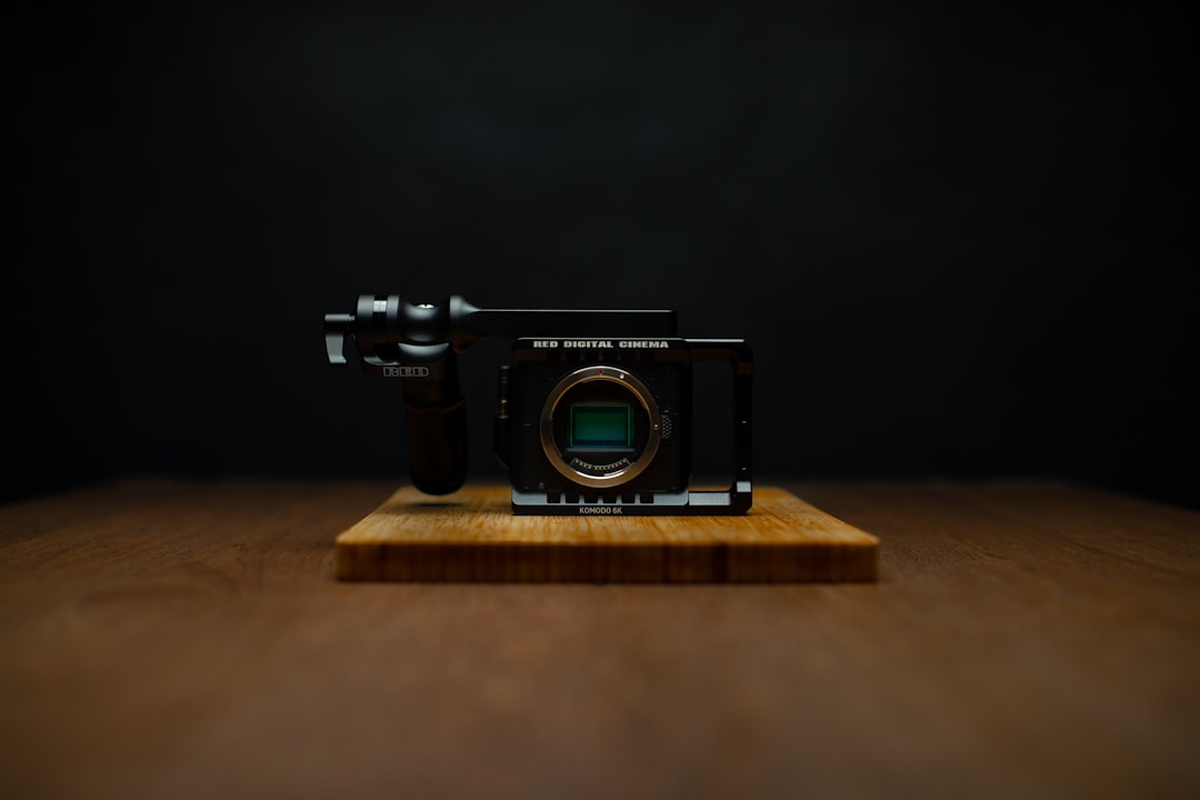 black and silver dslr camera on brown wooden table