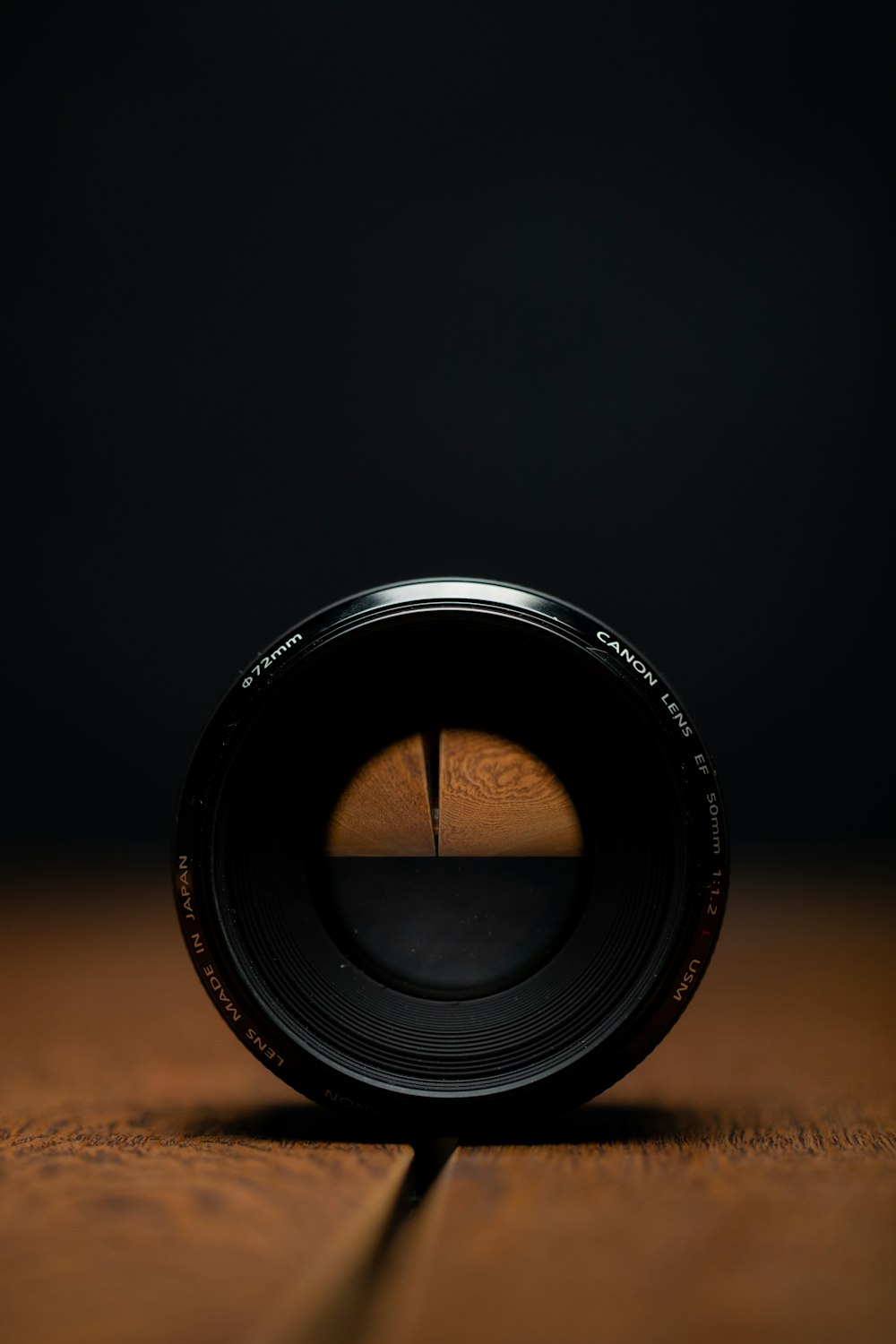 black camera lens on brown wooden table