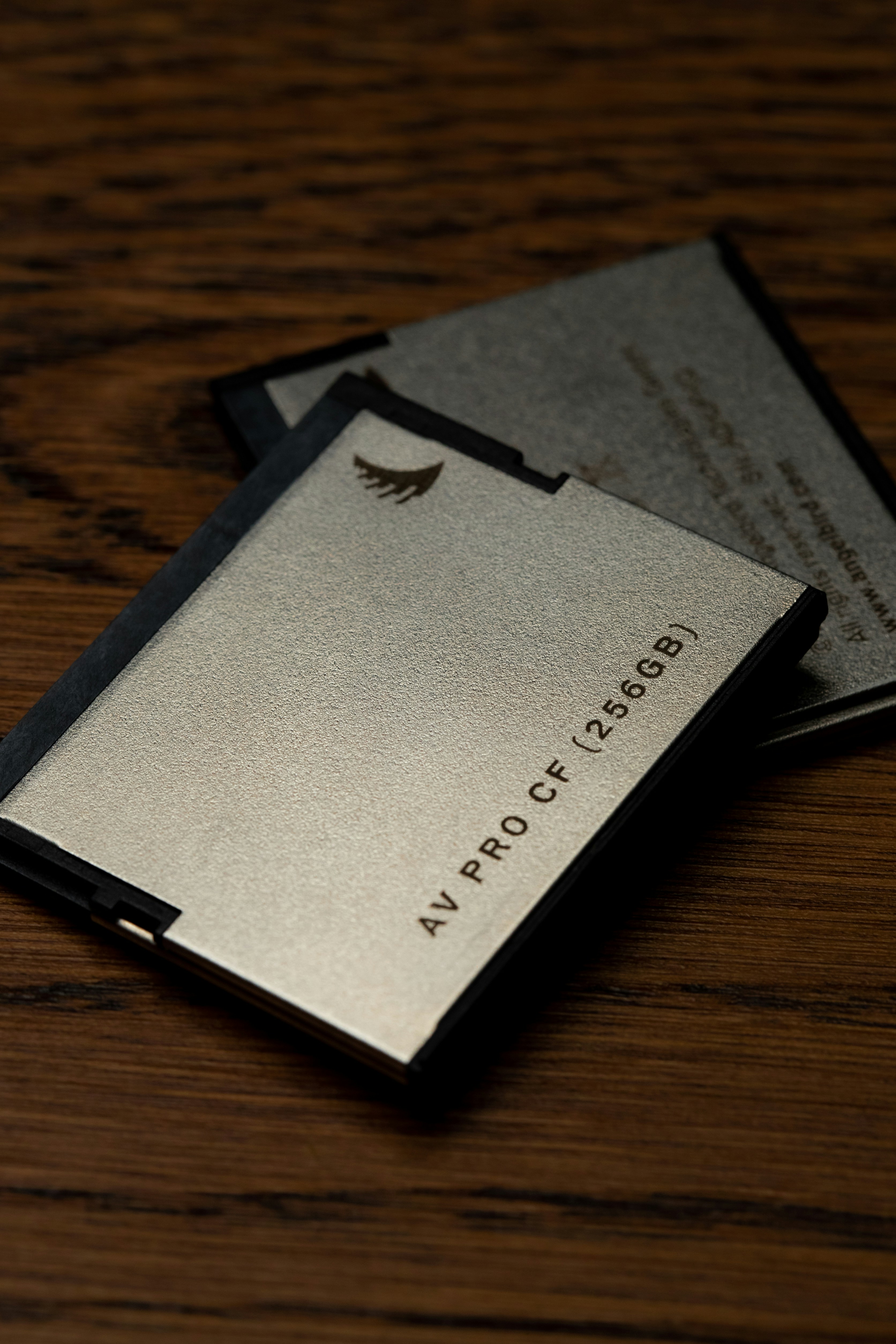 two business cards sitting on top of a wooden table