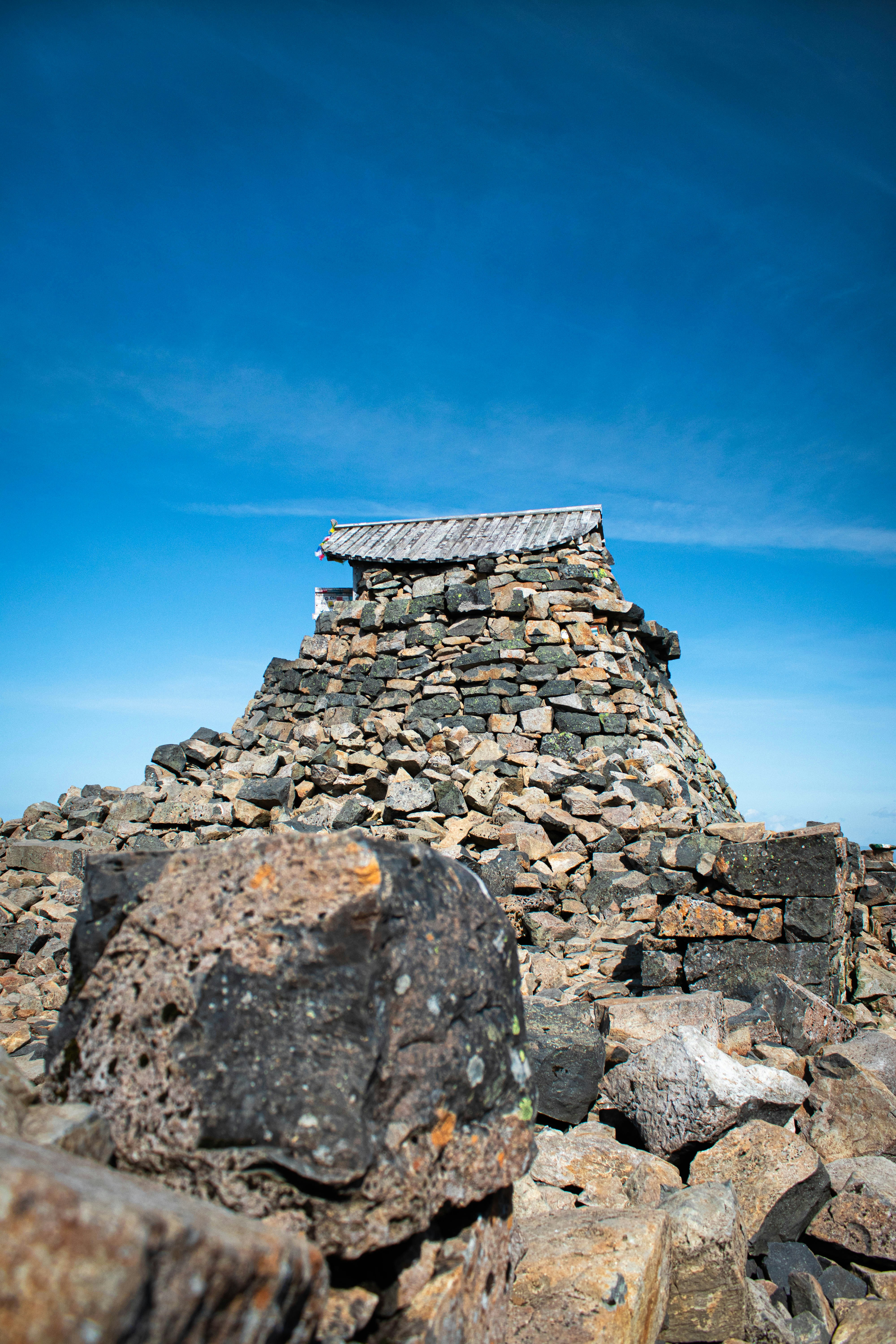昼間の青空の下の灰色と黒のコンクリートピラミッド