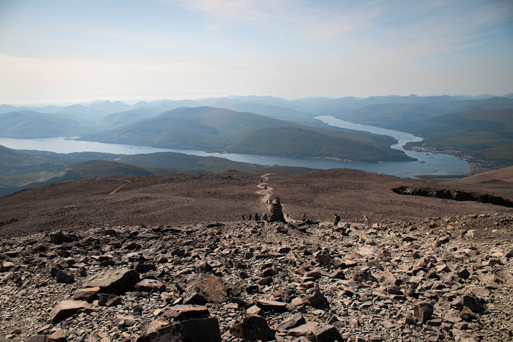 person sitting on rock near body of water during daytime