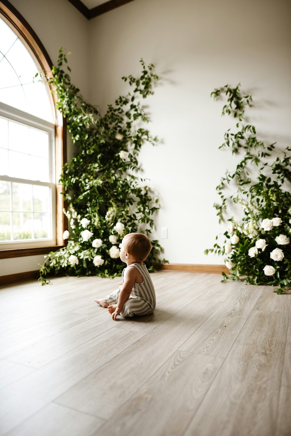 boy in white t-shirt and brown shorts sitting on floor