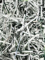 Shredding machine processing paper documents into fine pieces.