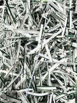 Shredding machine processing paper documents into fine pieces.