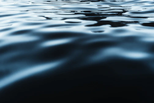 Abstract monochrome photo of rippling water reflecting light.