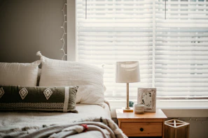 white and gray throw pillow on bed
