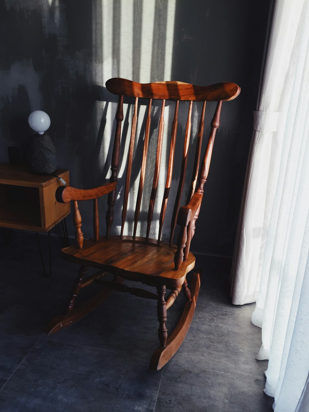 brown wooden rocking chair beside white wooden door