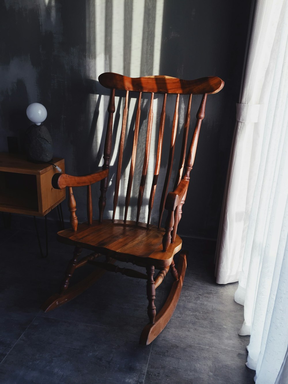 brown wooden rocking chair beside white wooden door