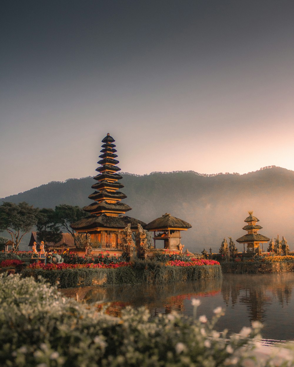 brown and white temple near body of water during daytime