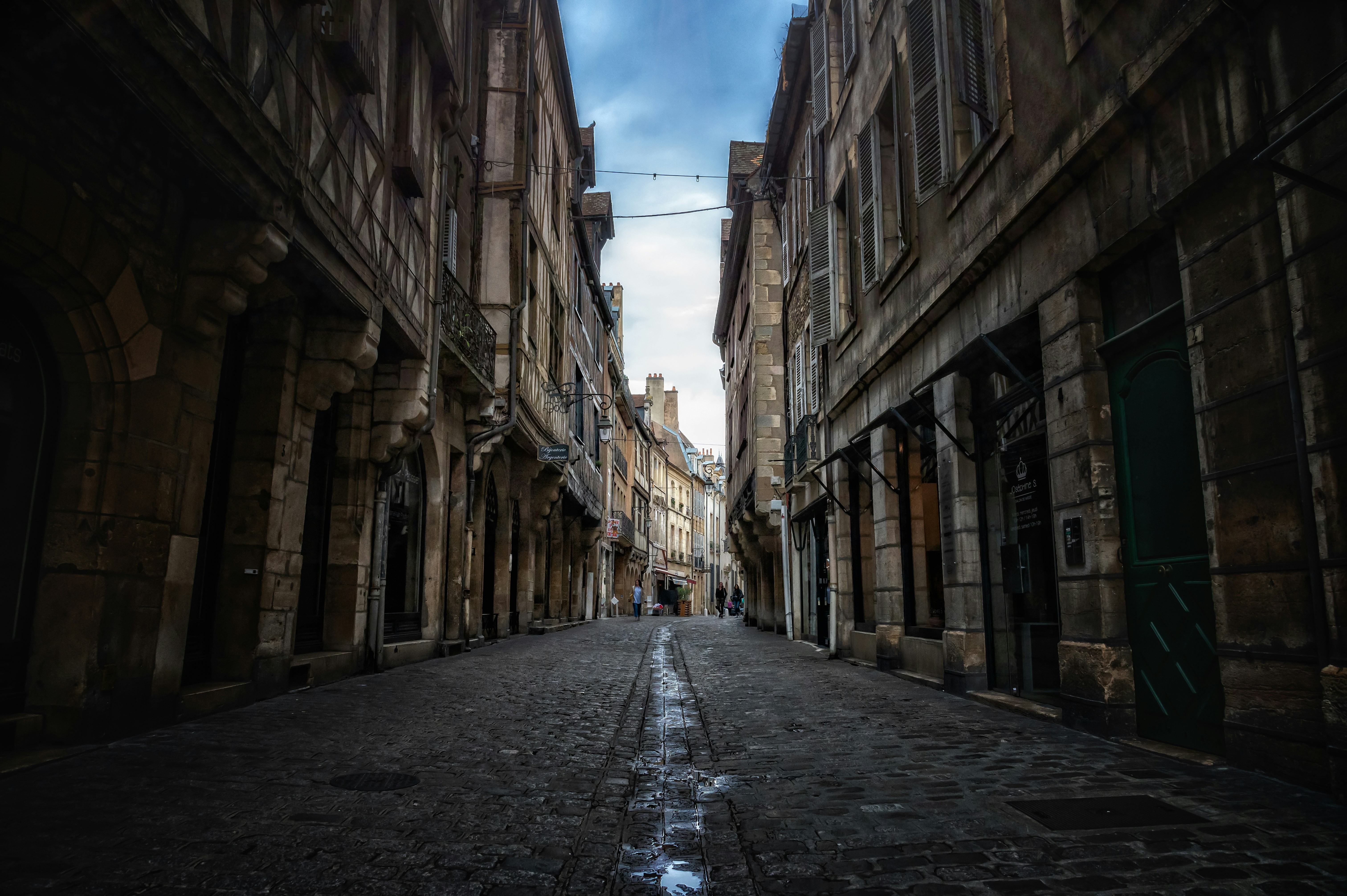 empty street between concrete buildings during daytime