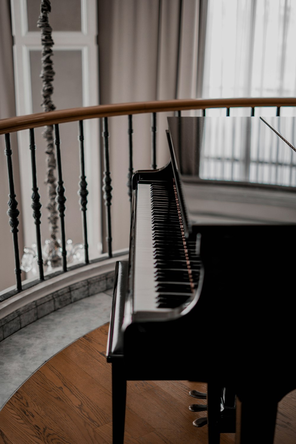 piano vertical negro sobre suelo de madera marrón