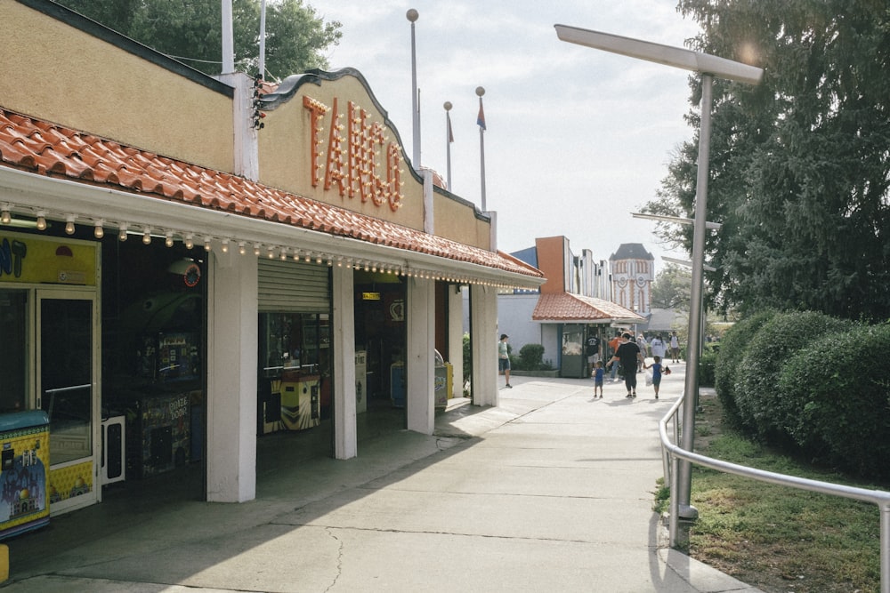 people walking on sidewalk near store during daytime