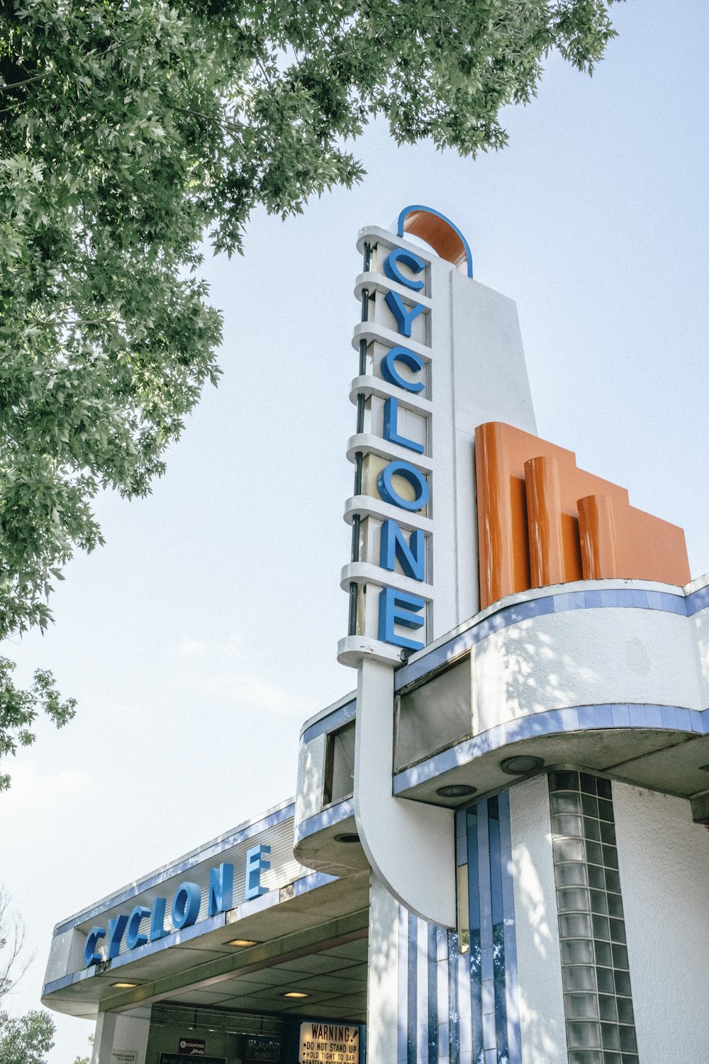 white and blue concrete building near green trees during daytime