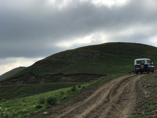 green grass field on hill under white clouds during daytime in Tavush Province Armenia