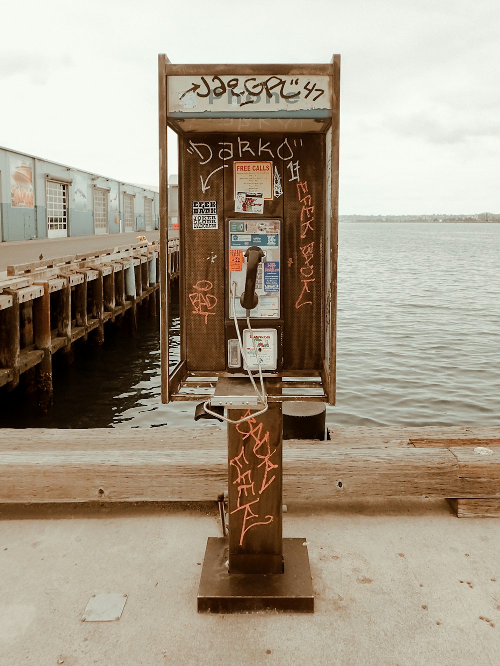 brown wooden telephone booth near body of water during daytime