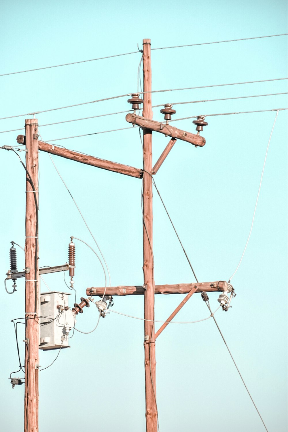 昼間の青空の下での茶色の電柱