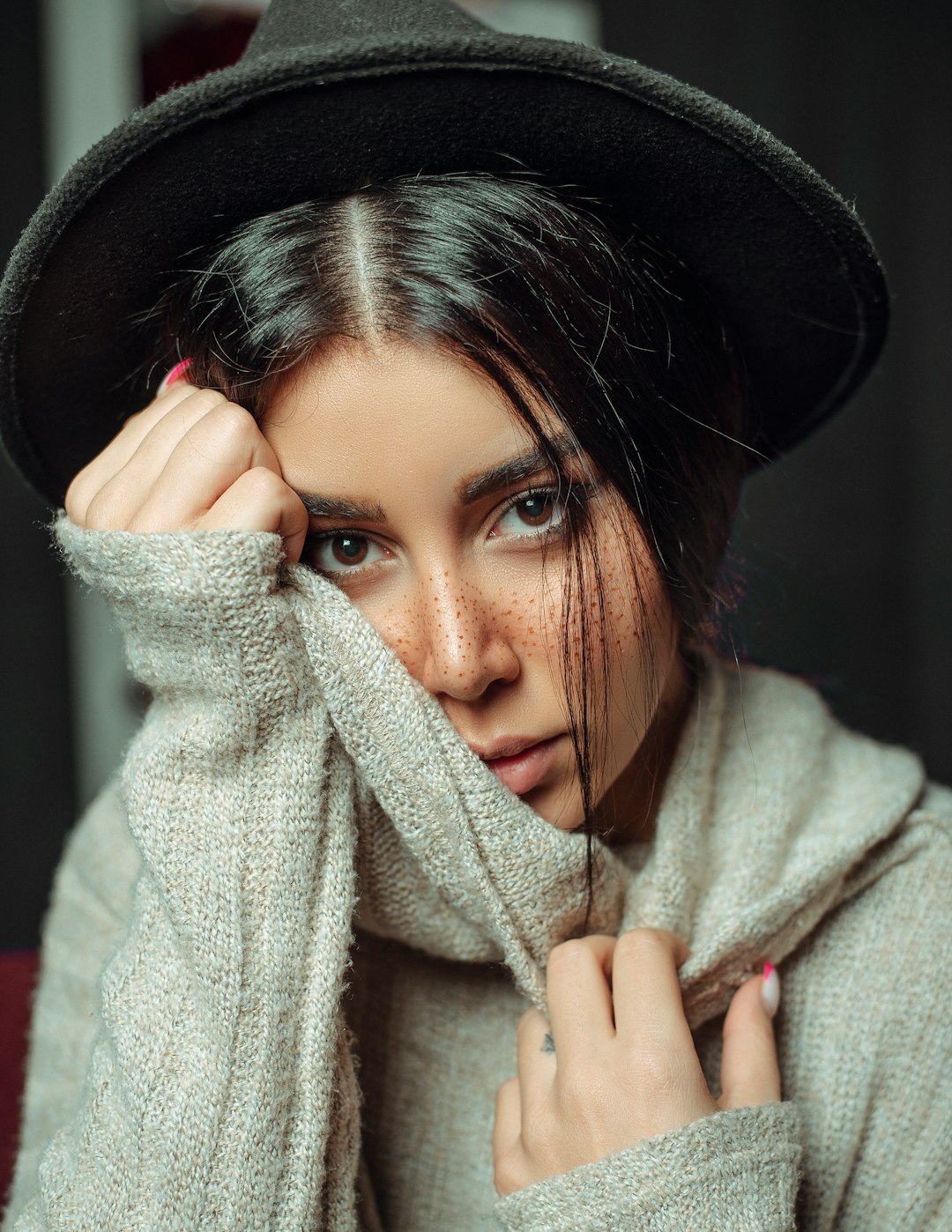 woman in black hat covering her face with white textile