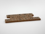 Wooden Scrabble tiles spell out the phrase 'Share Your Vision' against a plain white background. Each tile shows a letter with its corresponding point value, typical of Scrabble games.