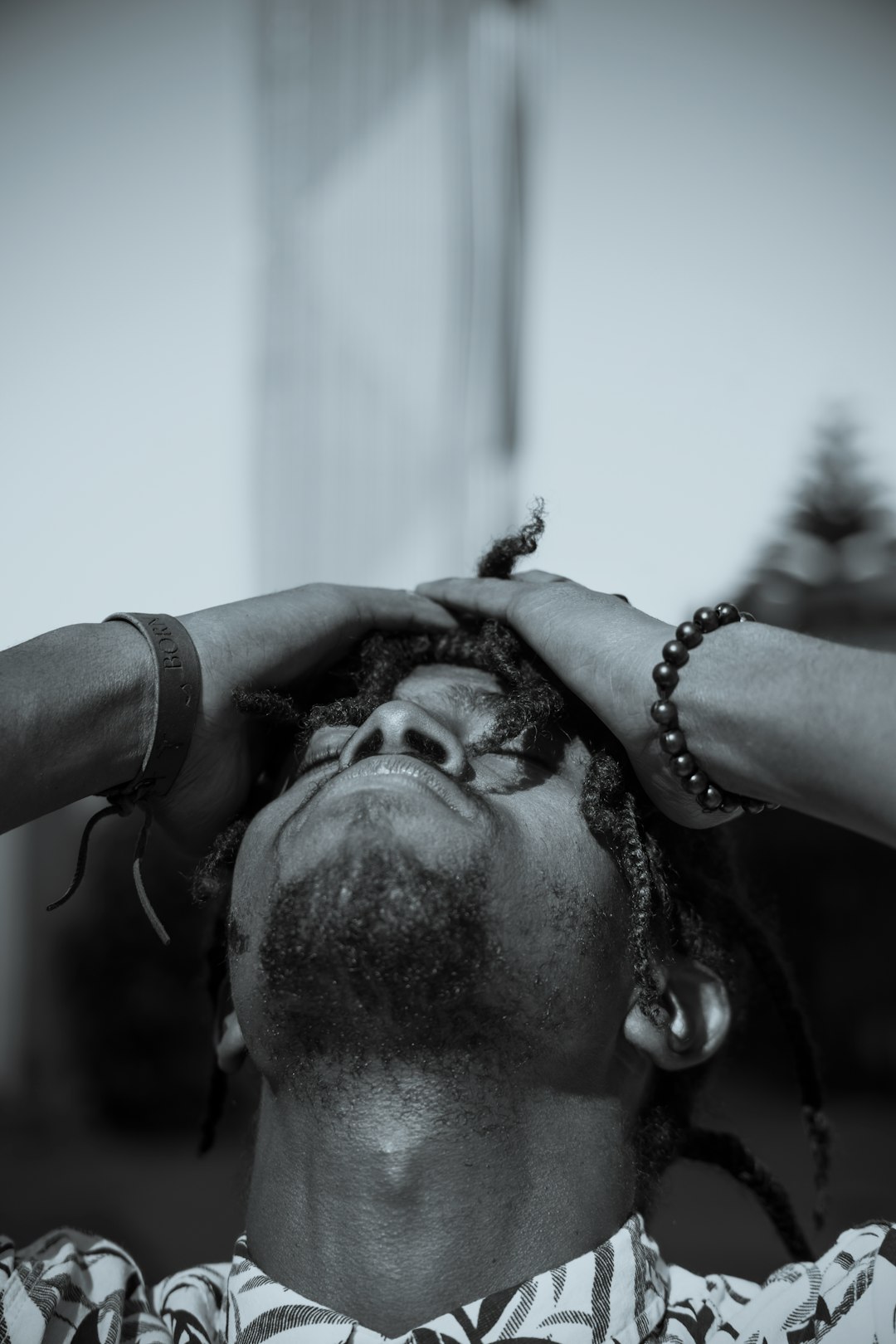 man in black shirt wearing silver beaded necklace