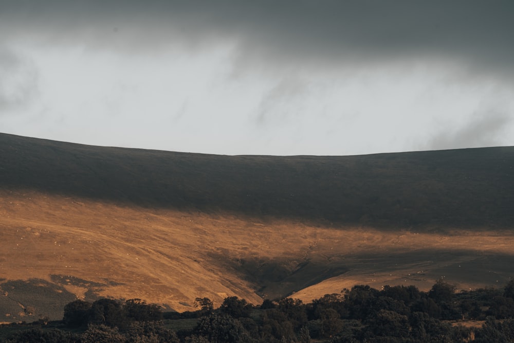 brown and green mountains under white clouds