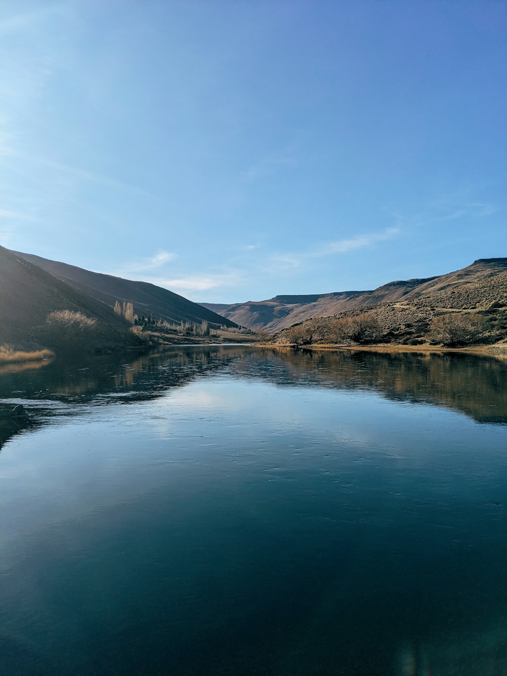 lake in the middle of mountains during daytime